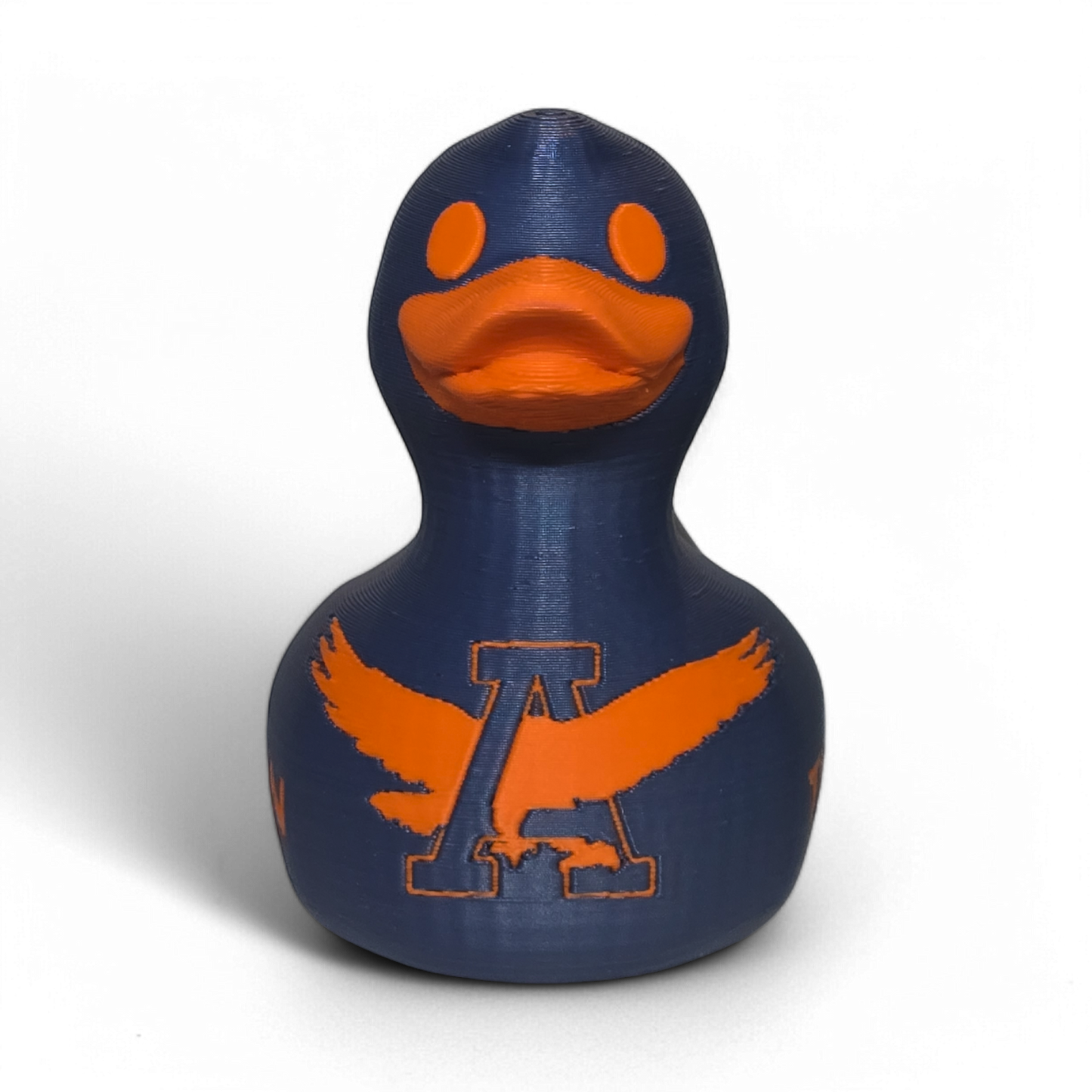 A small 3D printed PLA duck figurine in navy blue with orange accents, featuring the letters 'UA' and the word 'TIGERS' on the front, photographed on a light gray background.