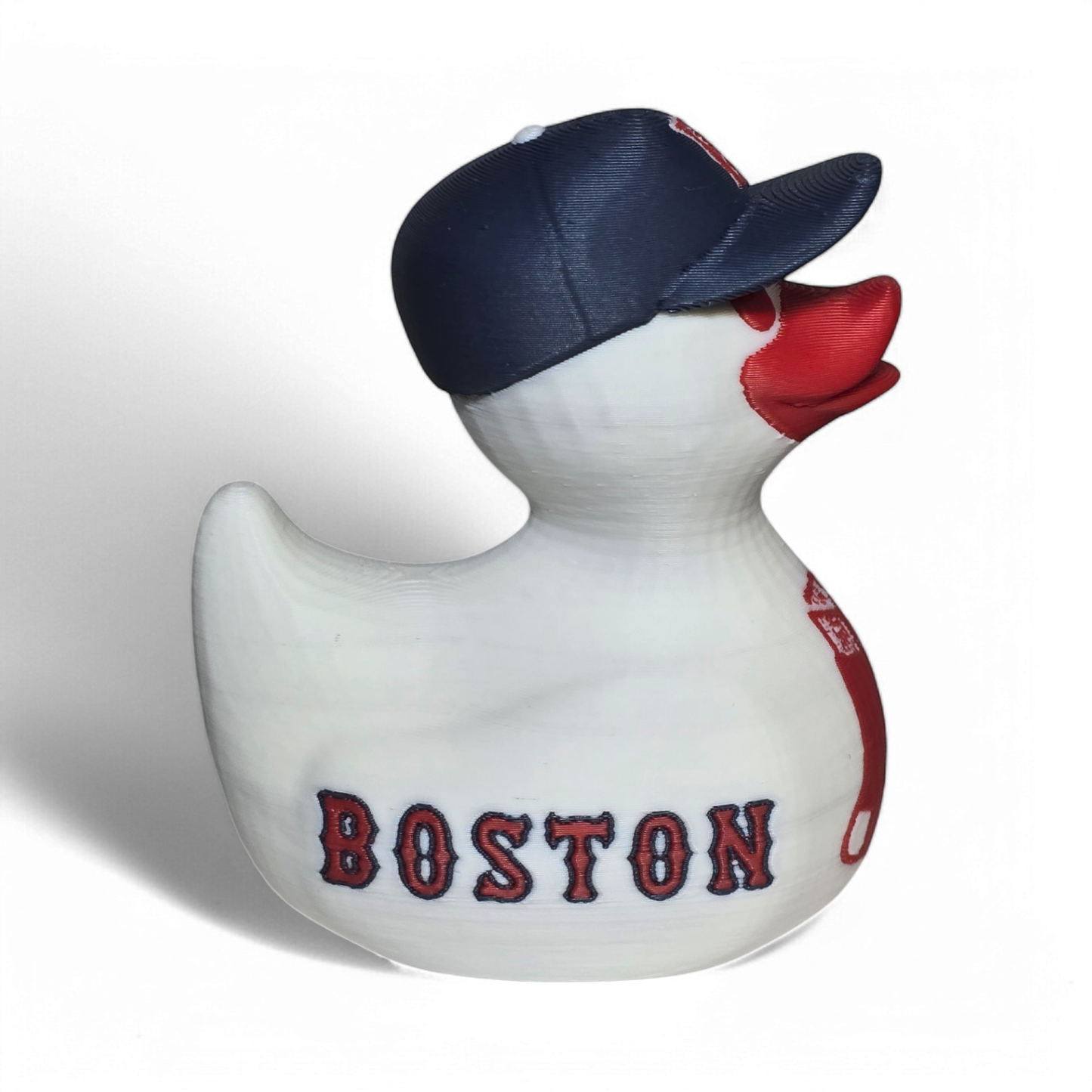 A white 3D printed PLA duck styled as a Boston Red Sox player, wearing a navy blue cap with a red 'B' logo and featuring red painted details and 'RED SOX' text on the side.