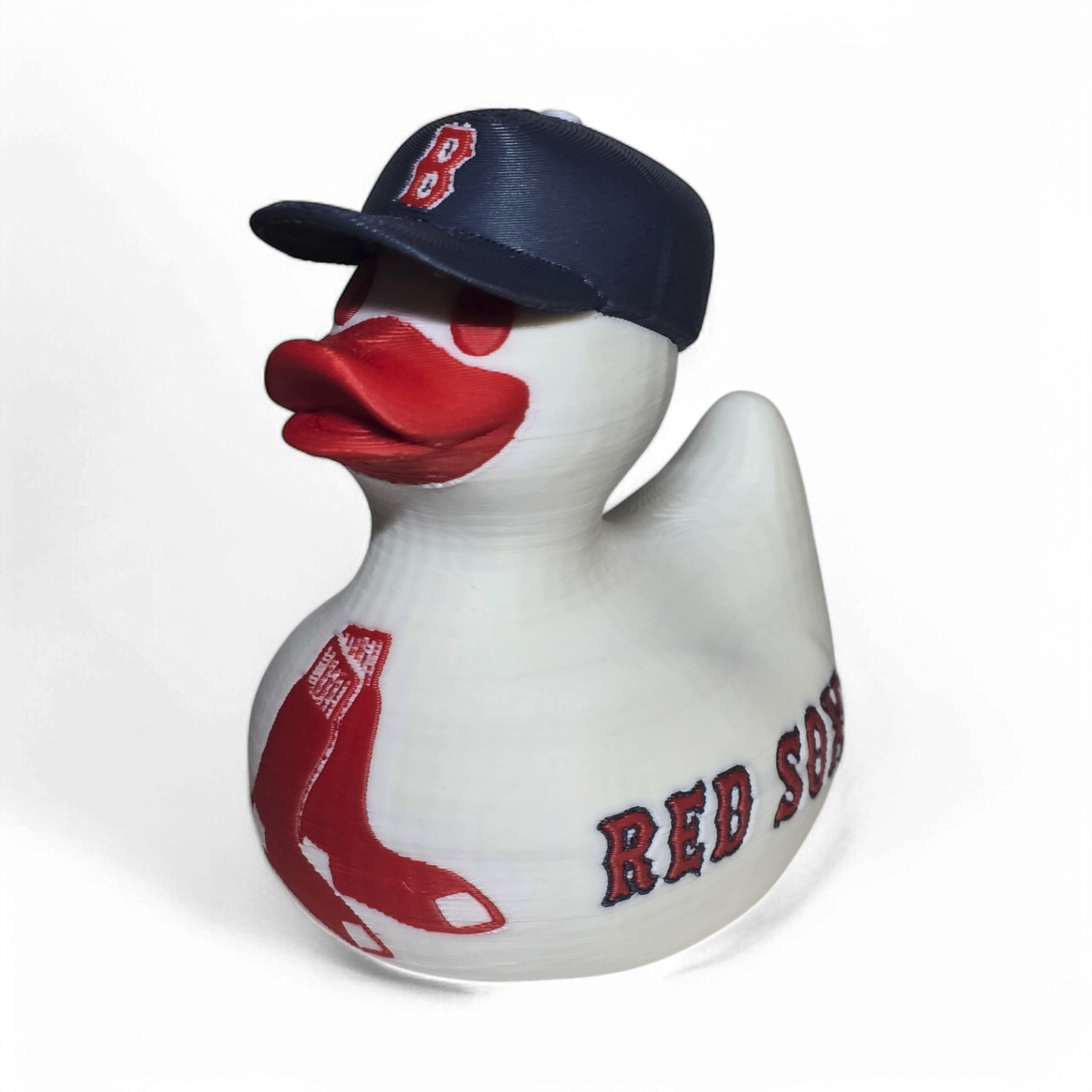 A white 3D printed PLA duck styled as a Boston Red Sox player, wearing a navy blue cap with a red 'B' logo and featuring red painted details and 'RED SOX' text on the side.