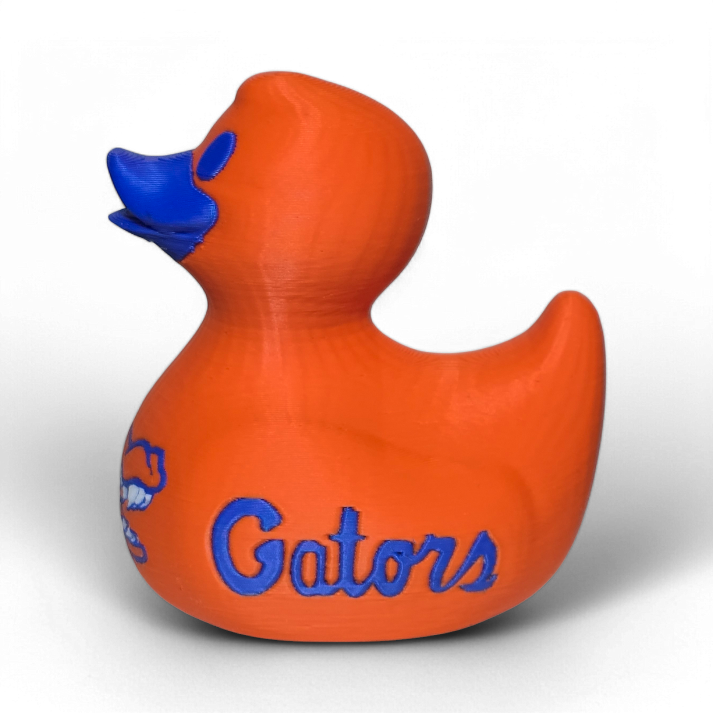 An orange 3D printed PLA duck with blue painted details, including a blue beak, blue eye, and blue Florida Gators logo and script on the side, shown on a white background.