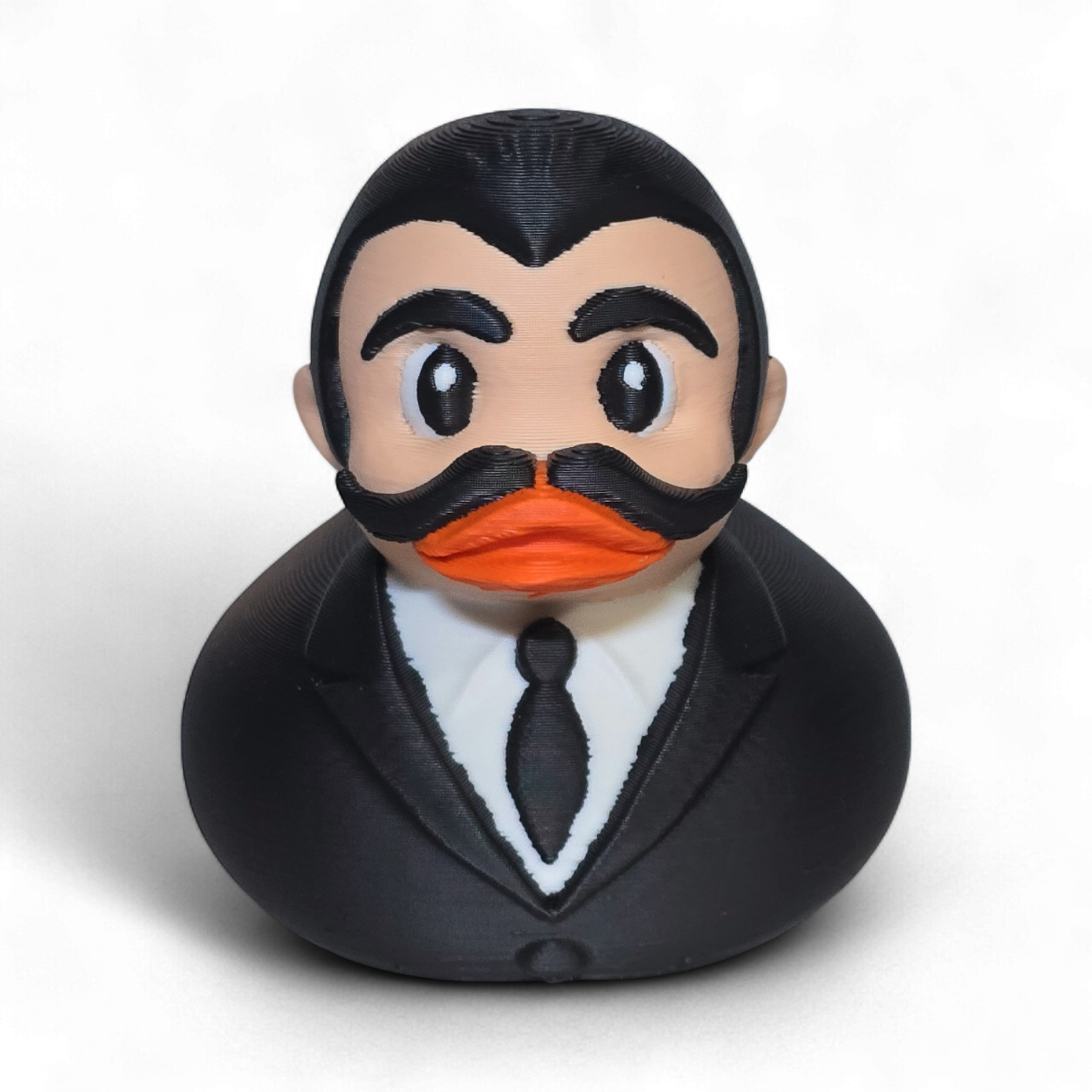 3D printed PLA duck with a formal outfit and mustache on a white background