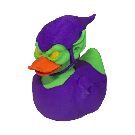 A 3D printed duck styled as the Marvel character Green Goblin, featuring a purple body and helmet, green skin, and an orange beak, isolated on a white background.
