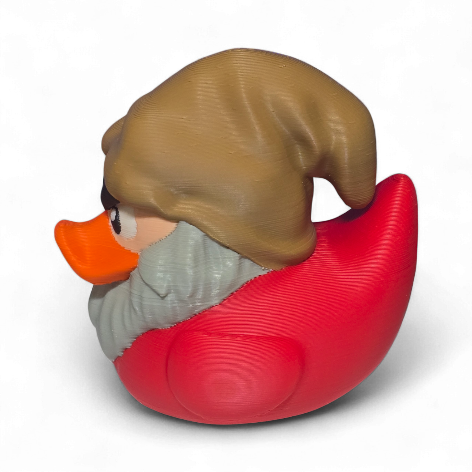 A 3D-printed figurine of a duck character resembling Grumpy, featuring a brown hat, orange beak, gray beard, and a red body, shown on a white background.