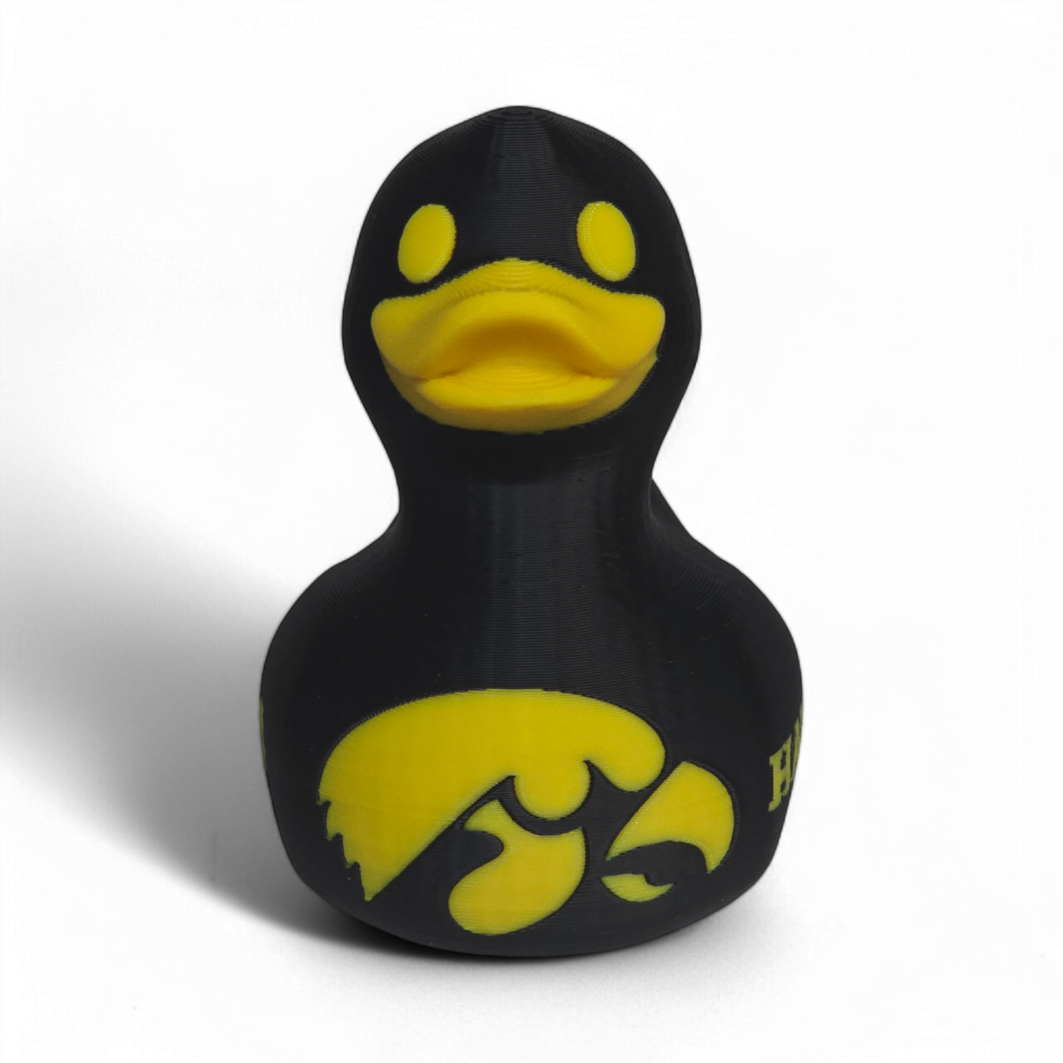 A black 3D Printed PLA duck with yellow accents, featuring the Iowa Hawkeyes logo and the word 'HAWKEYES' on its side, set against a plain white background.