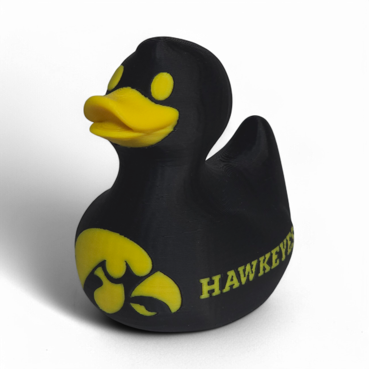 A black 3D Printed PLA duck with yellow accents, featuring the Iowa Hawkeyes logo and the word 'HAWKEYES' on its side, set against a plain white background.