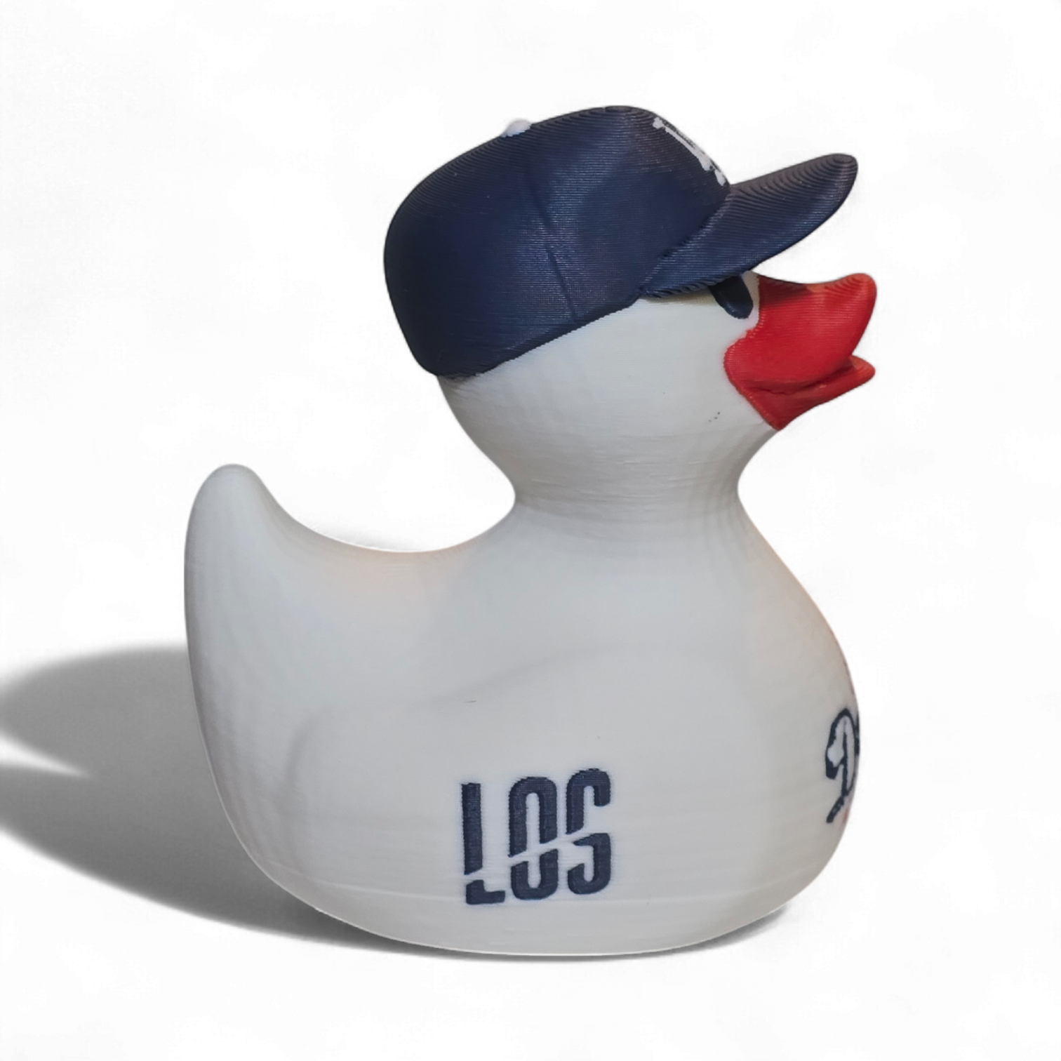 A white 3D printed PLA duck styled as a Los Angeles Dodgers player, featuring a navy blue cap with a white 'LA' logo, a red beak, and navy and red 'Dodgers' and 'ANGELES' graphics on its body, set against a plain white background.