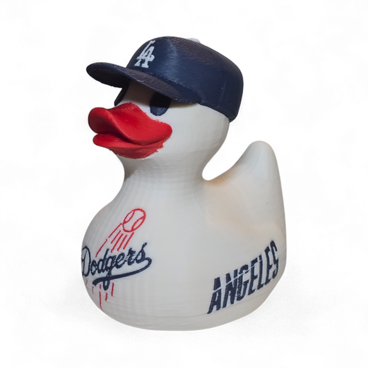 A white 3D printed PLA duck styled as a Los Angeles Dodgers player, featuring a navy blue cap with a white 'LA' logo, a red beak, and navy and red 'Dodgers' and 'ANGELES' graphics on its body, set against a plain white background.