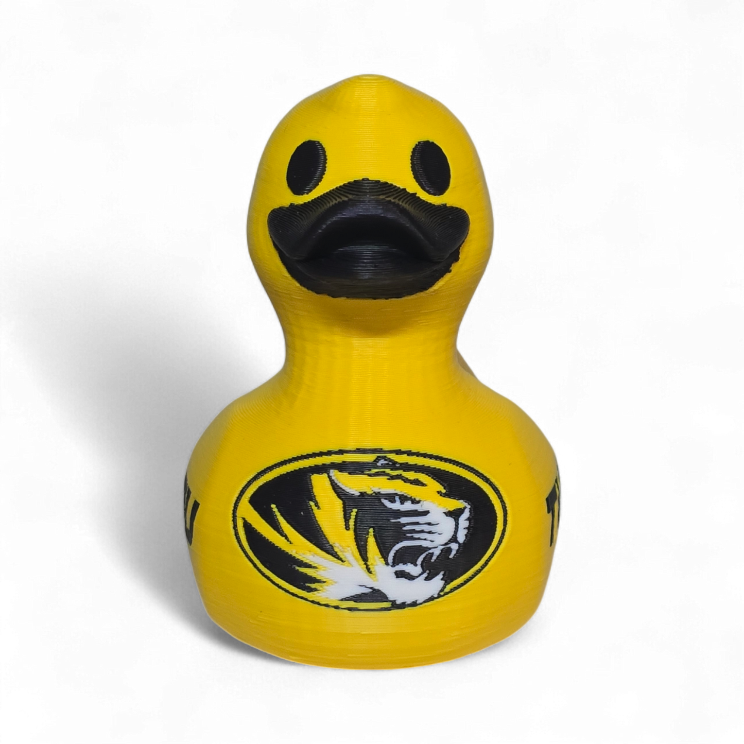 A bright yellow 3D Printer PLA duck with a black beak and black printed graphics, including a tiger logo and the word 'TIGERS' on the side, shown on a plain white background.