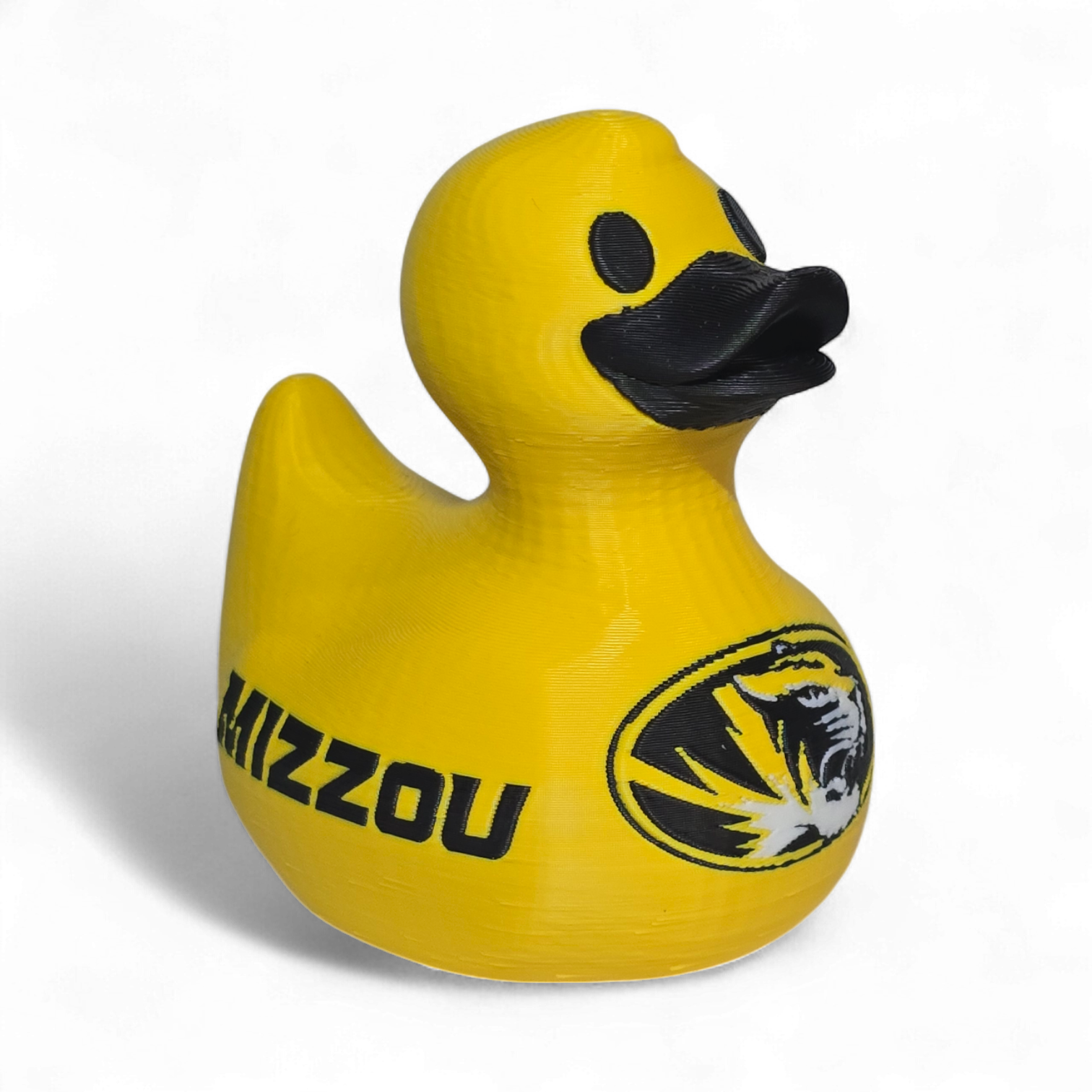 A bright yellow 3D Printer PLA duck with a black beak and black printed graphics, including a tiger logo and the word 'TIGERS' on the side, shown on a plain white background.