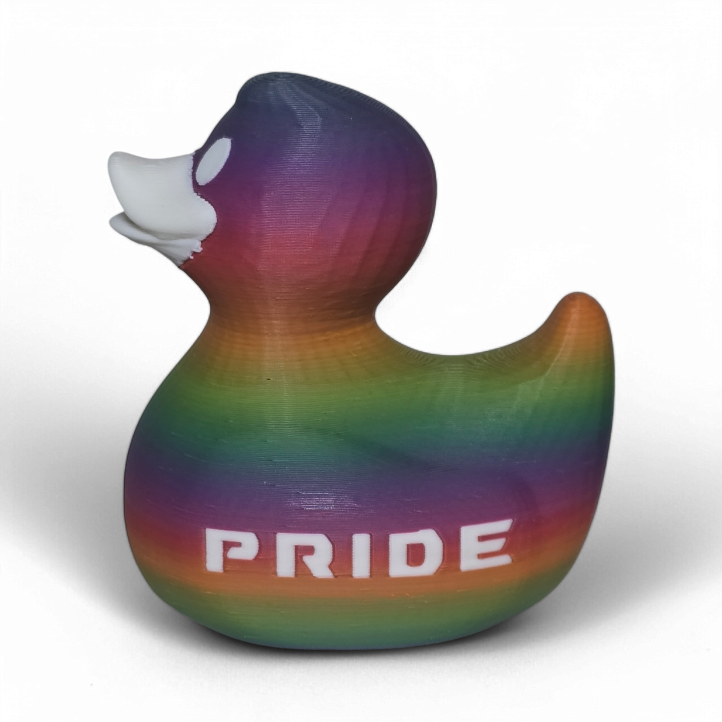 A 3D-printed PLA duck toy featuring a vibrant rainbow gradient pattern with the word 'PRIDE' printed in white on its side, set against a plain white background.