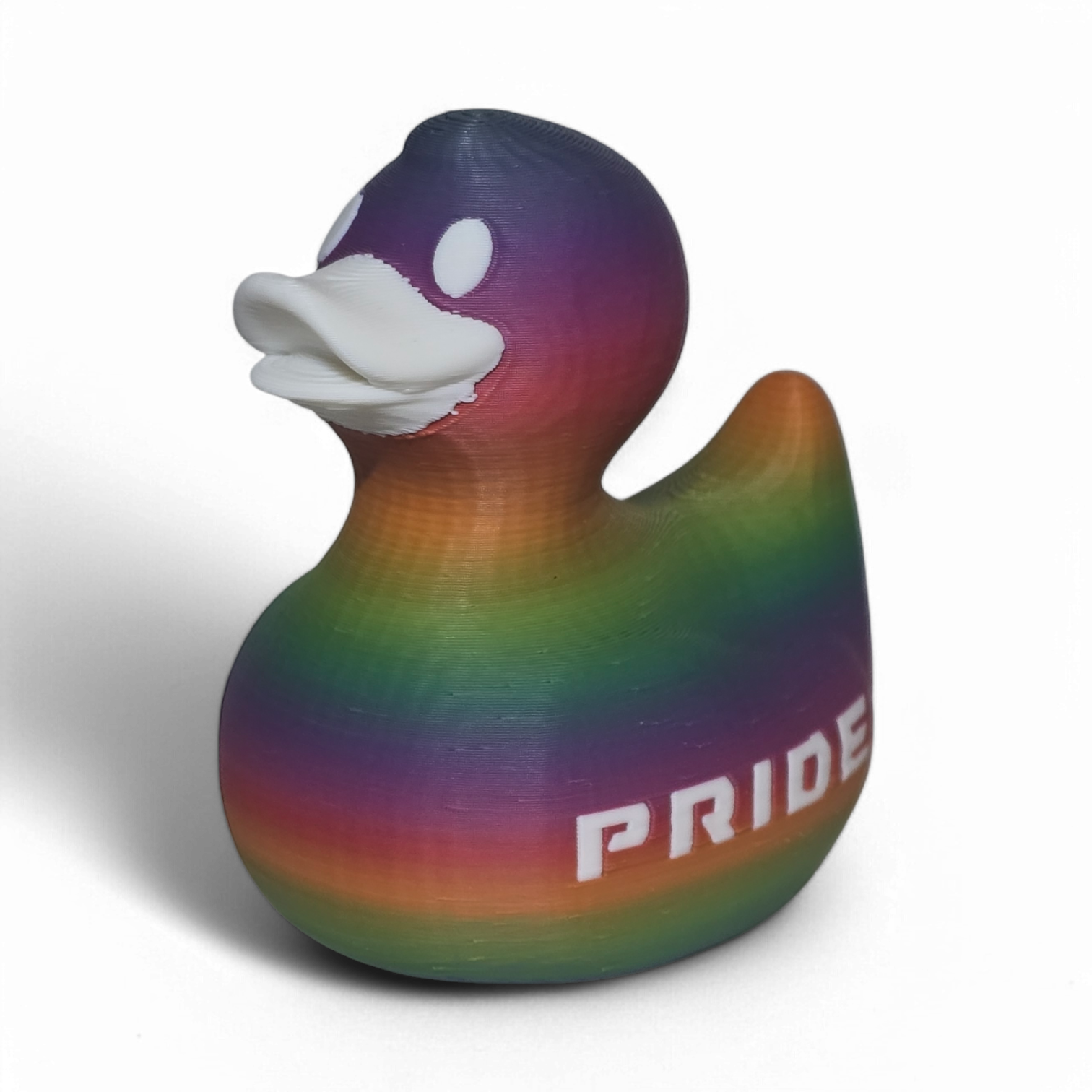 A 3D-printed PLA duck toy featuring a vibrant rainbow gradient pattern with the word 'PRIDE' printed in white on its side, set against a plain white background.