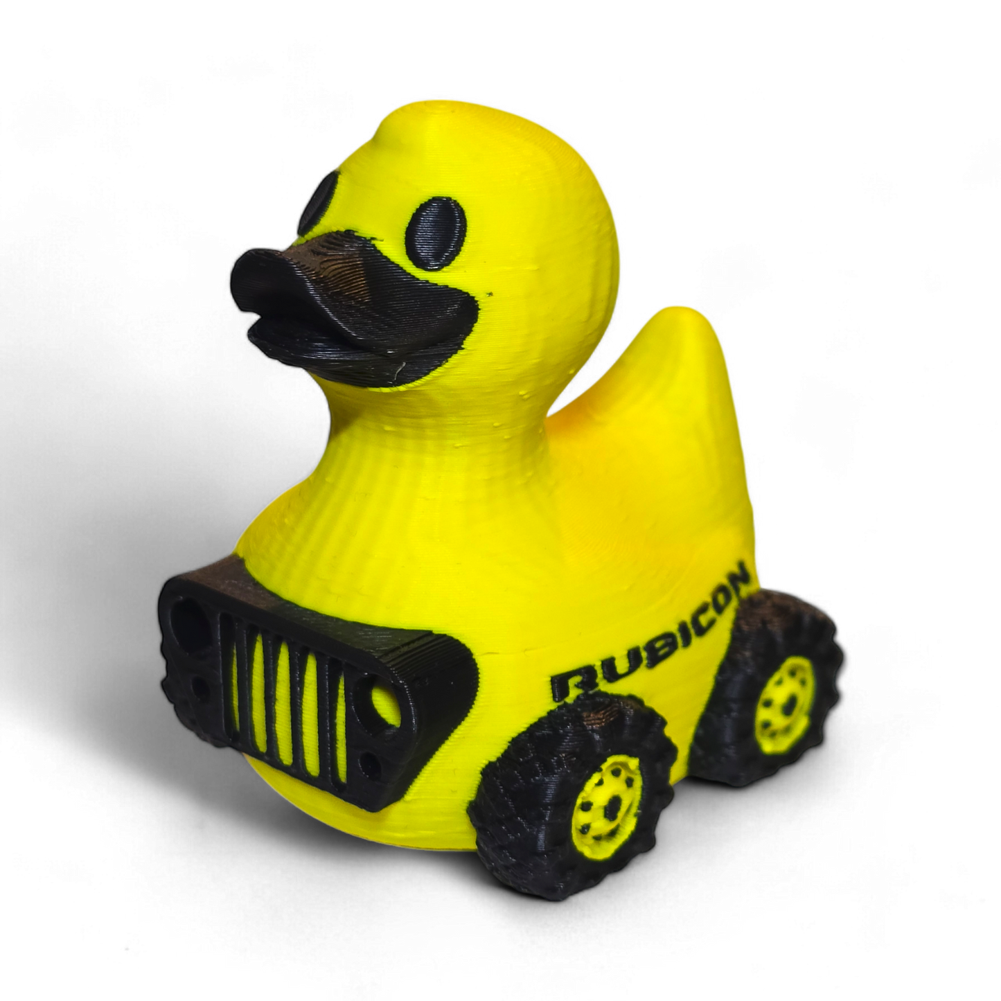 Yellow 3D printed duck with black details resembling a Rubicon Jeep on a white background