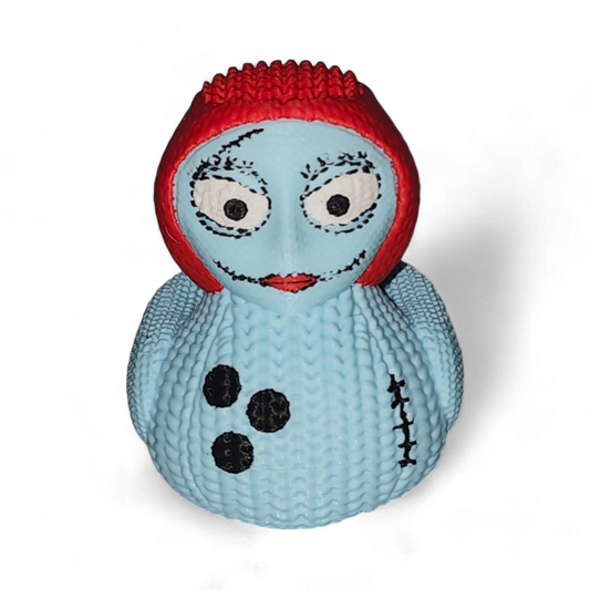 A 3D Printed PLA duck, featuring a light blue body with black spots and a stitched seam, topped with a bright red textured head resembling hair, and detailed with cartoon eyes and a smile.