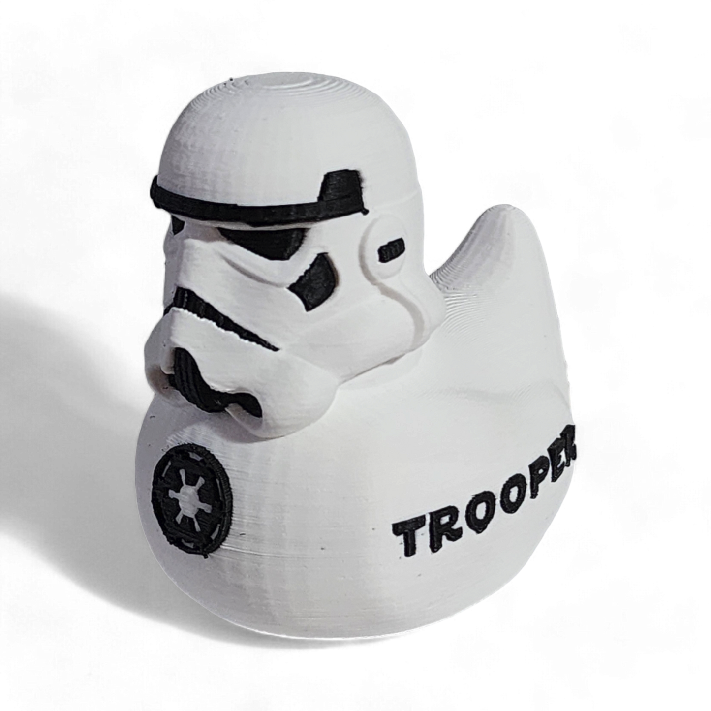 A white 3D printed PLA duck shaped like a Stormtrooper helmet, with black printed details including the Imperial crest and the word 'TROOPER' on the side, shown on a white background.
