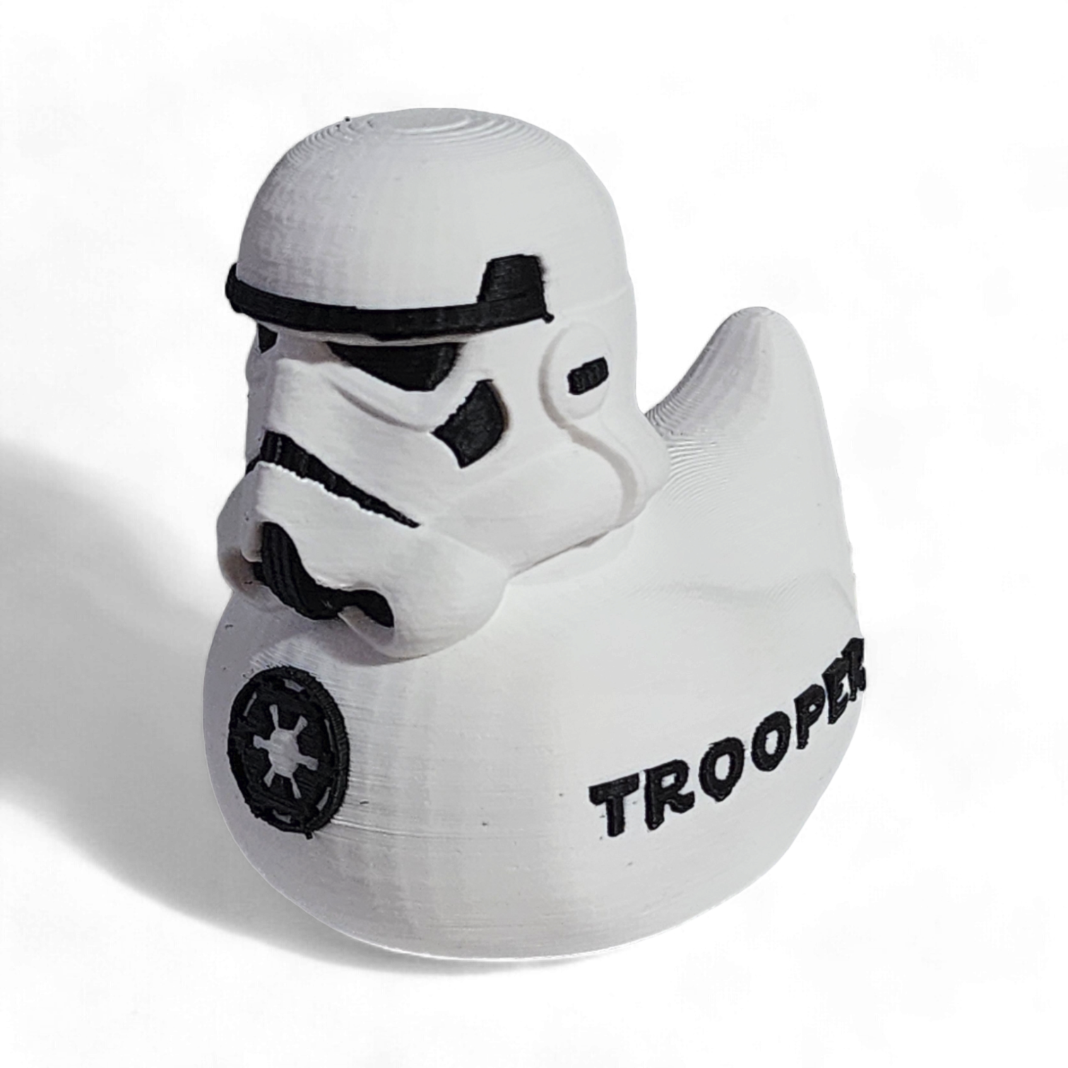 A white 3D printed PLA duck shaped like a Stormtrooper helmet, with black printed details including the Imperial crest and the word 'TROOPER' on the side, shown on a white background.