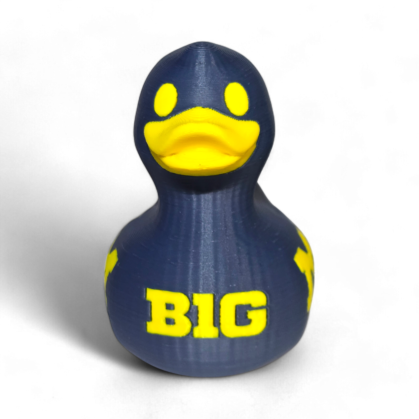 A 3D-printed PLA duck in navy blue with bright yellow accents, featuring the letters 'BIG' on the front, set against a plain white background.