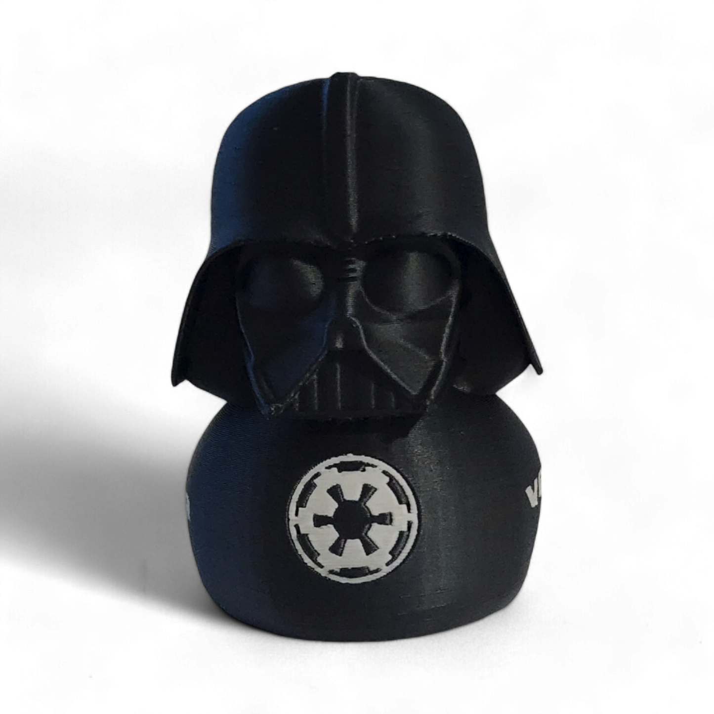 A Darth Vader themed helmet-shaped 3D printed PLA duck , featuring the white Star Wars VADER logo and an Imperial crest on the side, set against a plain white background.