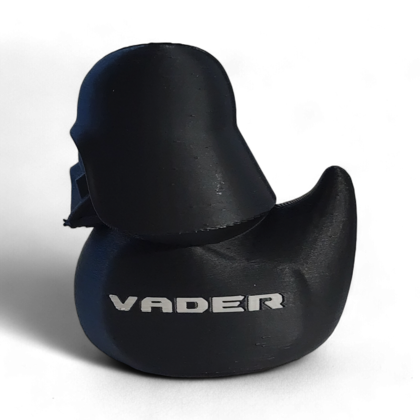 A Darth Vader themed helmet-shaped 3D printed PLA duck , featuring the white Star Wars VADER logo and an Imperial crest on the side, set against a plain white background.