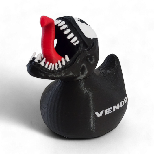 A black 3D Printed PLA duck with a Venom-themed design, featuring a red tongue sticking out, white teeth, a white and black pattern on the head, and the word 'VENOM' printed in white on the side.