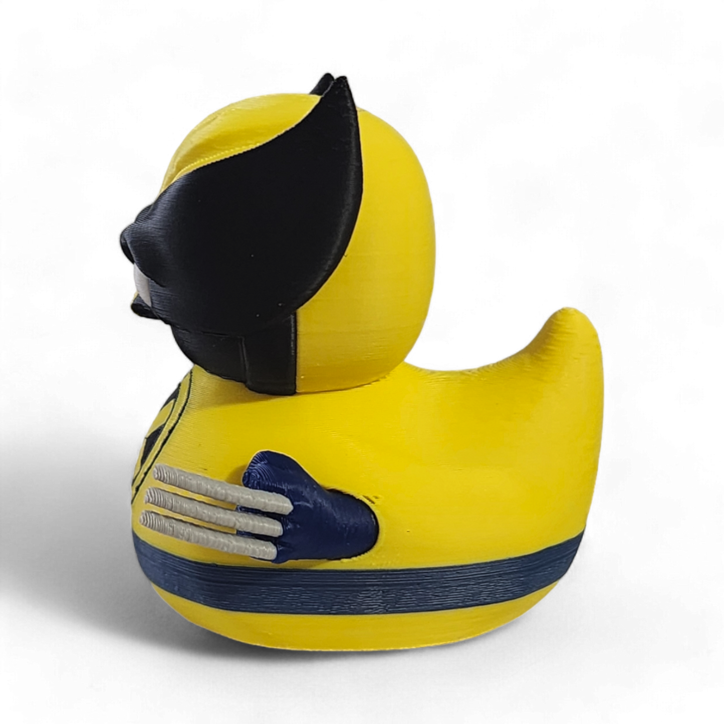 A small Wolverine figurine or toy in a bright yellow costume with black mask, blue accents, and white claws, photographed on a plain white background.